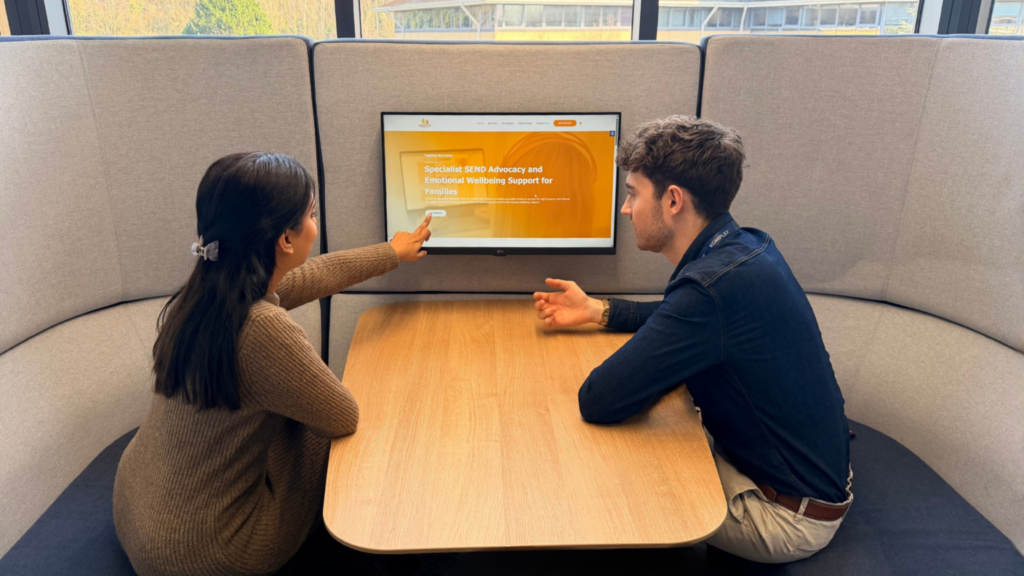 Team members from Komplex Group looking at the SENDaid website on a laptop.